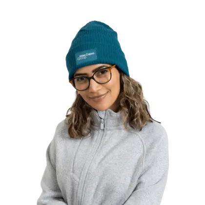 woman wearing teal winter hat with atlas copco group logo