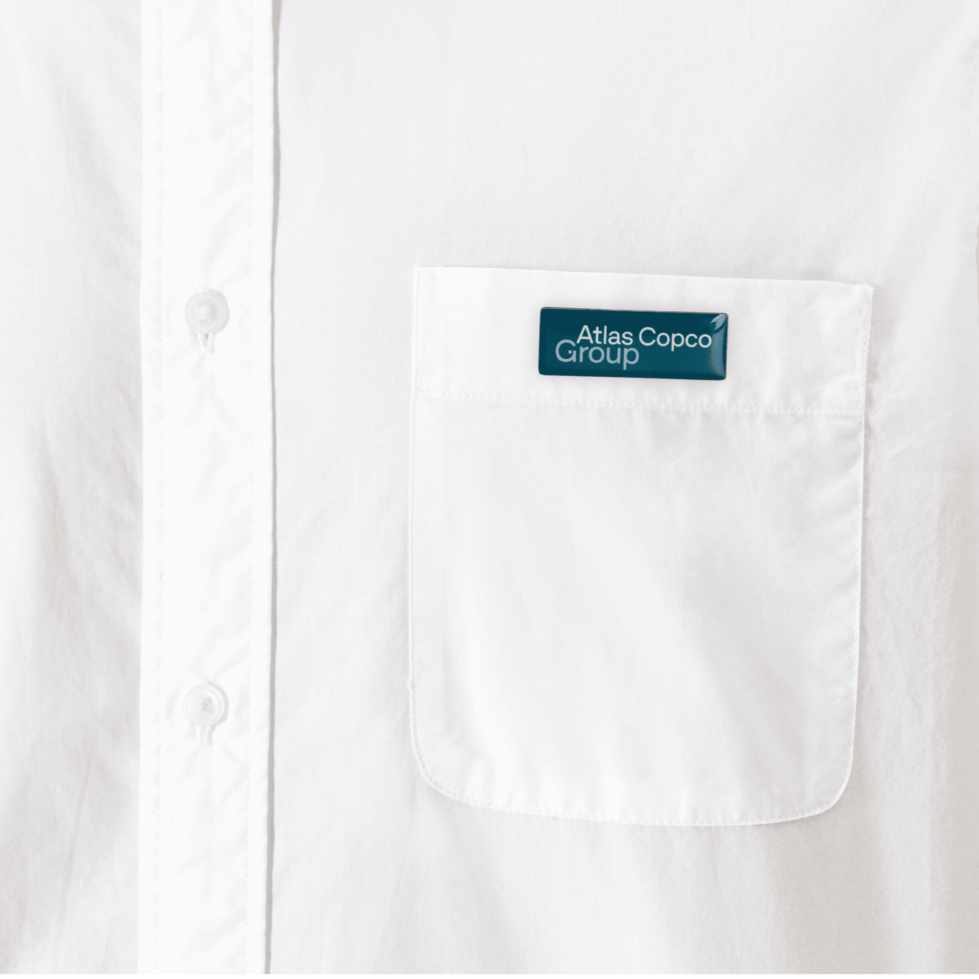 metal pin with atlas copco group logo on shirt close up