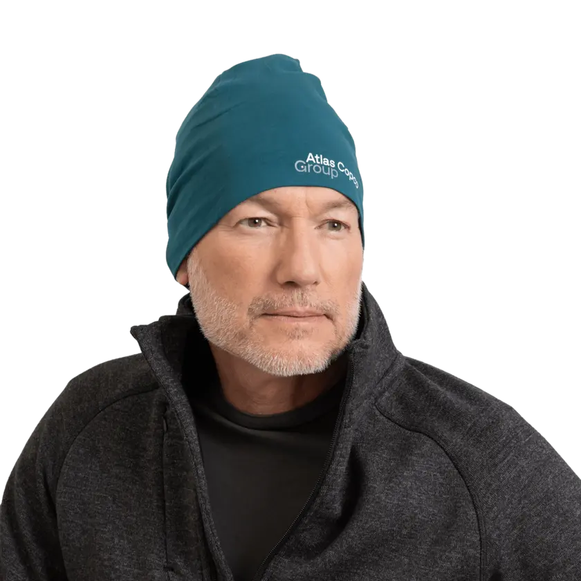 man wearing teal beanie with atlas copco group logo